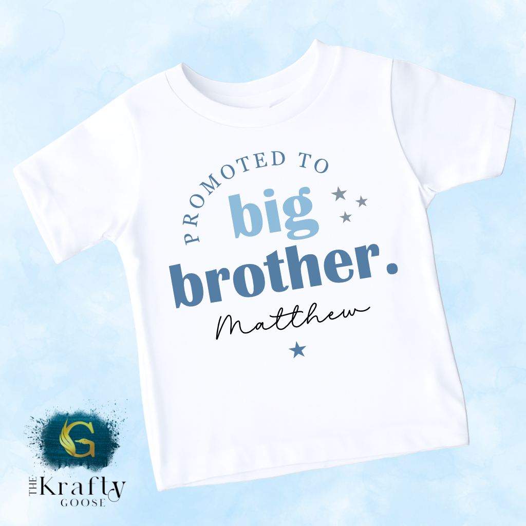 A white t-shirt with text that reads "Promoted to big brother. Matthew" printed on it.