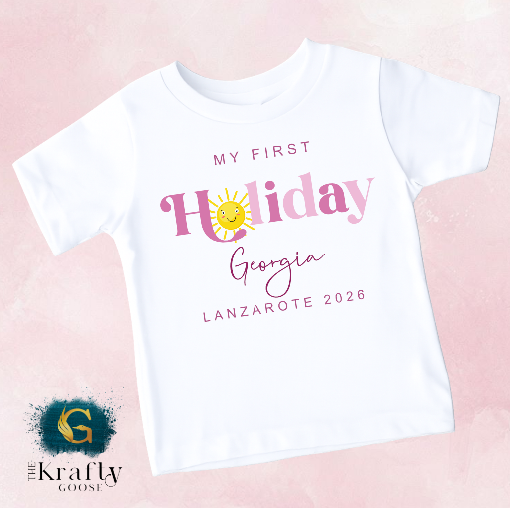 A white t-shirt with text and graphics printed on it, including a sun and the text "My first Holiday Georgia Lanzare 2016".