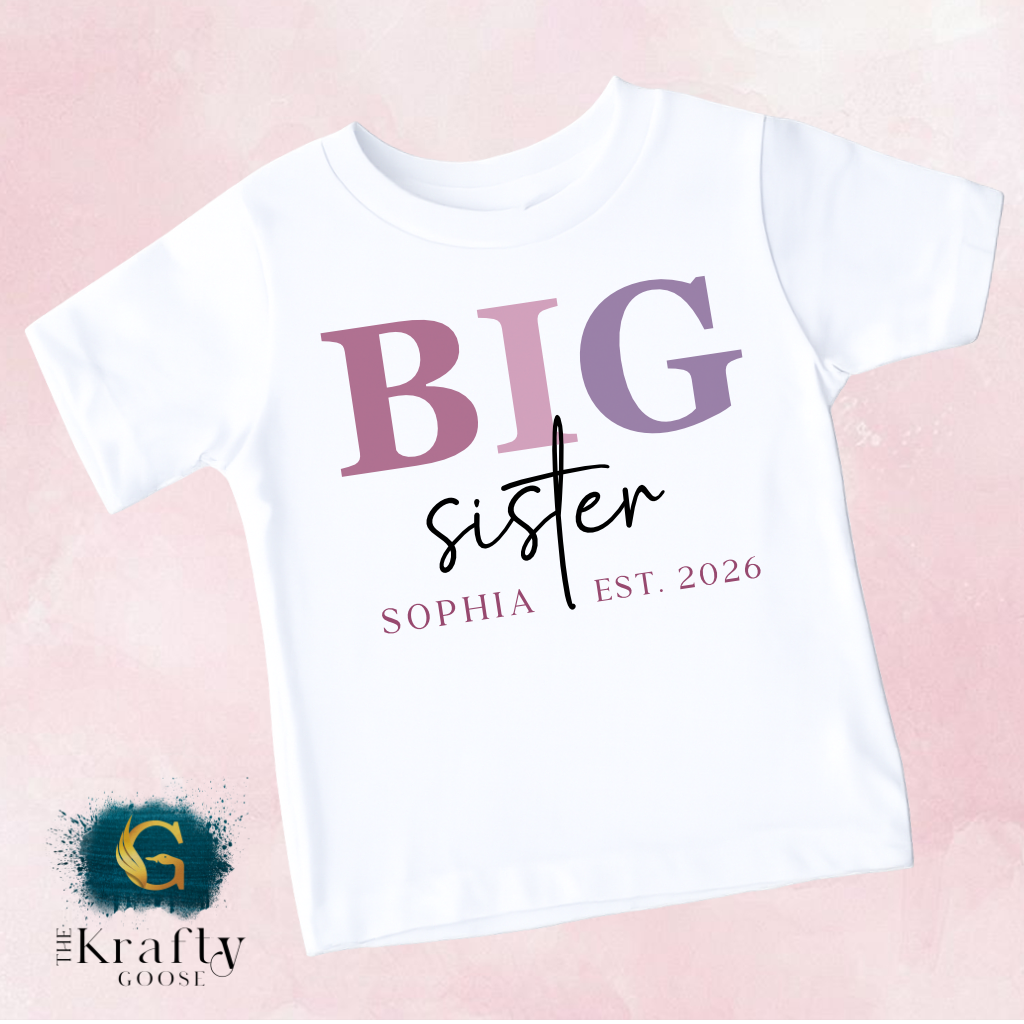 A white t-shirt with the text "BIG sister" printed on it, along with the text "SOPHIA EST. 2026" below it.