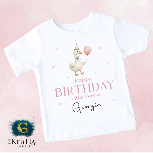 A white t-shirt with a cartoon image of a duck holding a balloon and the text "Happy Birthday Little Goose Georgia" printed on it.